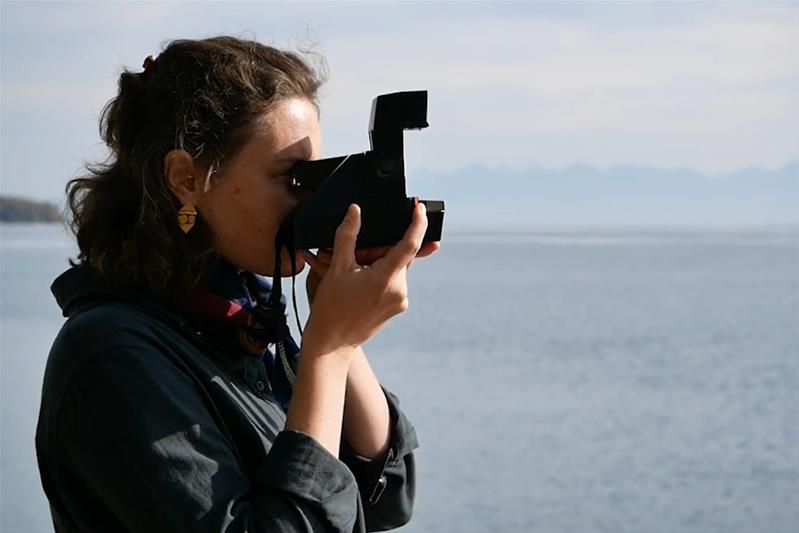 Eine Frau fotografiert eine Landschaft.